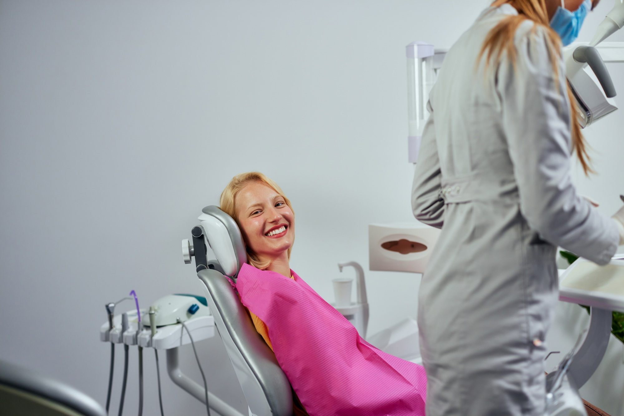 Smiling patient showing bright smiley while sitting on dental chair